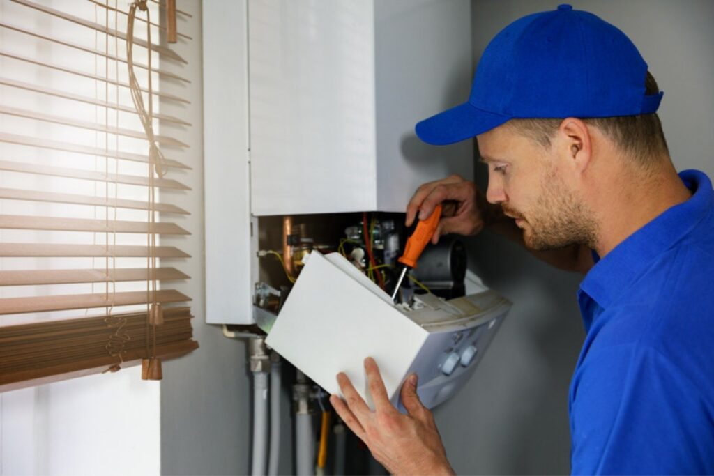 Technician repairing a wall-mounted gas boiler